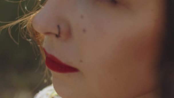 用红色口红捂住美丽女人的嘴 卷曲着她站在树旁的头发 高质量的4K镜头 — 图库视频影像