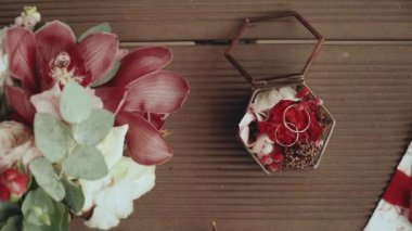 Gelinin düğün aksesuarları, düğün buketi, alyanslar, davetiye kartı. Gelinin sabahı. Ahşap zeminde düğün aksesuarları. Yüksek kaliteli FullHD görüntüler