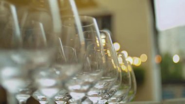 Gün ışığında yansıyan şeffaf şarap kadehleri. Süper yavaş çekim. Lüks bir restoranda ziyafet masasında boş şarap kadehleri. Yüksek kaliteli FullHD görüntüler