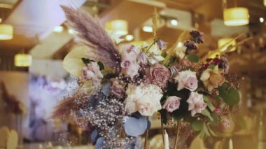 Bir buket pastel çiçekle süslenmiş servis masası ağır çekimde. Düğün dekoru, çiçekler. Yüksek kaliteli FullHD görüntüler