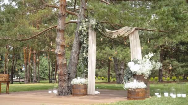 公園のスローモーションショットでパステル調の色あせた花で飾られた雑草のアーチ 素朴な結婚式のスタイル 高品質のフルHd映像 — ストック動画