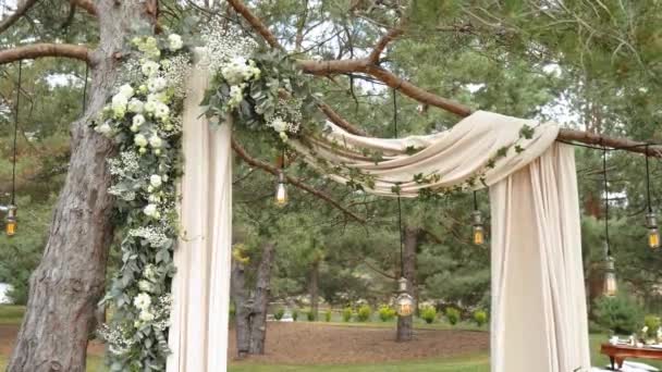 パステルフェードの花や公園のスローモーションショットで木製の椅子で飾られたクローズアップ結婚式のアーチ 素朴な結婚式のスタイル 高品質のフルHd映像 — ストック動画