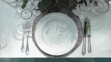 Güzel bir düğün dekoru, hepsi mavi, gri renkli kamera ile süslenmiş, ağır çekimde hareket ediyor. Masanın üzerinde çok güzel lüks tabaklar var. Yüksek kaliteli FullHD görüntüler