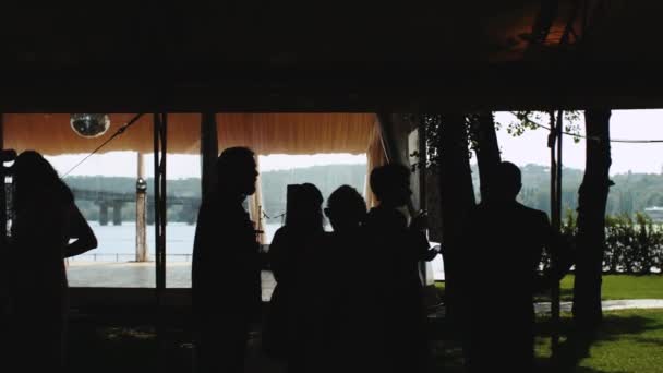 Sylwetki Ludzi Mówiących Stojących Restauracji Panoramicznym Widokiem Rzekę Zwolnione Tempo — Wideo stockowe