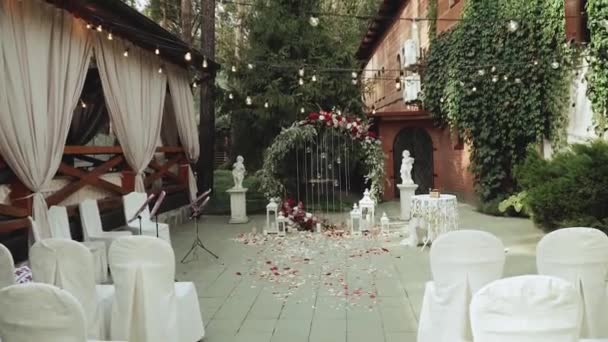 Arco Casamento Com Flores Vermelhas Cadeiras Brancas Guirlanda Lâmpada Sobre — Vídeo de Stock