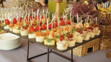 Restoranda ya da otelde aperatif kanepesi olan güzel dekore edilmiş yemek masası. Yemek servisi, şirket doğum günü partileri ya da düğün kutlaması. Yüksek kaliteli FullHD görüntüler