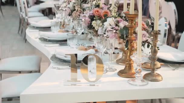 美しい結婚式の装飾 すべてのパステルカラーで飾られ カメラはスローモーションを移動します テーブルの上にはお祝いのプレートとグラスが置かれています 高品質のフルHd映像 — ストック動画