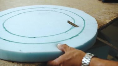 Close-up hand male worker cutting foam rubber for the production of a sofa in a furniture factory , slow motion. High quality 4k footage