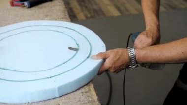 Close-up hand male worker cutting foam rubber for the production of a sofa in a furniture factory close-up shot, slow motion.High quality 4k footage