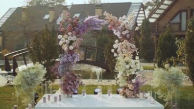View of Wedding floral decorations of flowers in pastel faded colors slow motion, outside wedding ceremony in park, the suns rays shine through. FullHD footage