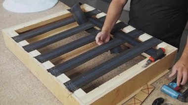 Bir işçi mobilya fabrikasında bir kanepe yapar. Erkek eli, kanepenin bir parçasını yapıyor. Yavaş çekim. Yüksek kalite 4k görüntü