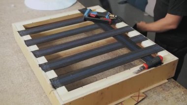 Bir işçi mobilya fabrikasında bir kanepe yapar. Erkek eli, kanepenin bir parçasını yapıyor. Yavaş çekim. Yüksek kalite 4k görüntü