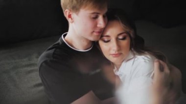 Couple in love hugs, medium shot the couple hugging with their eyes closed, slow motion, guy touches female hair. High quality 4k footage