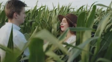 Genç hippi adamlar mısır tarlasının önünde sarılıp öpüşüyorlar ya da orta boy çiftlikte. Beyaz bir adam kollarında kızları tutuyor, gözleri kapalı. Çift, randevu, aşk ve yaşam tarzı konsepti ağır çekim.