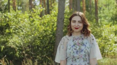 Çekici bir kadının portresi. Gözleri kapalı ve elinde yüzüne yakın bir buket çivi var. Yüksek kalite 4k görüntü