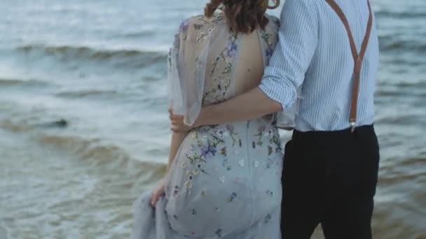 幸せなカップル一緒にビーチサイドを歩いて 彼らは素晴らしいと非常にロマンチックで 手を取り合って 足を水の上を歩いて感じている 高品質4K映像 — ストック動画