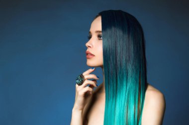 Mavi saçlı güzel bir kız. Peri gibi güzel bir kadın. Mücevher yüzüğü ve rengi saçı olan.