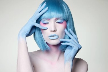 Mavi saçlı ve boyalı güzel bir kız. Peri güzeli genç bayan.