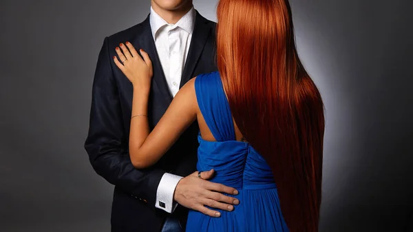 穿着晚礼服的女人在穿着西服的男人手里 可爱的情侣 可爱的红头发姑娘勾引她英俊的男朋友 — 图库照片