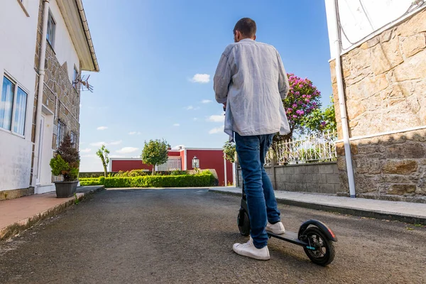 路上の電動スクーターに立つ普段着姿の青年の姿 — ストック写真