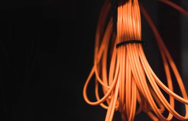 Siyah zemin üzerinde turuncu fiber optik kablo rulosu