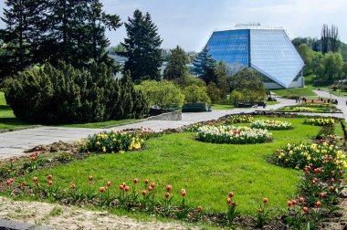 Çiçekli ve modern cam kaplamalı şehir manzarası. Botanik Bahçesi