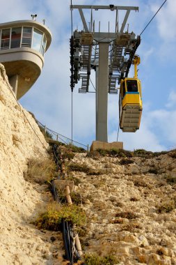 Güneşli bir günde kayaların üstünde teleferik.