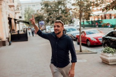 Gömlekli bir adam sokakta yürür ve arkasını döner.