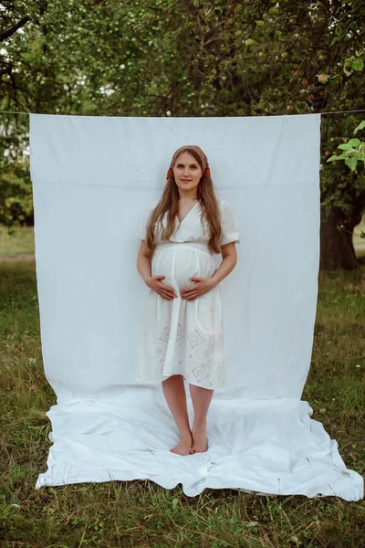 Een Zwanger Meisje Een Witte Jurk Poseert Tegen Een Witte — Stockfoto