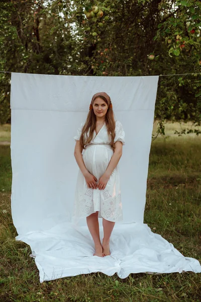 Uma Menina Grávida Vestido Branco Posa Contra Fundo Branco Jardim — Fotografia de Stock