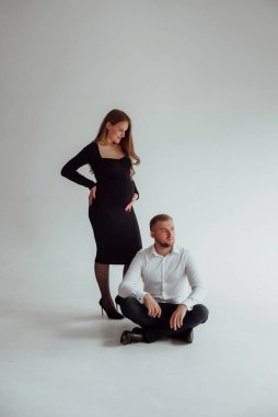 Stüdyoda beyaz bir geçmişi olan mutlu evli bir çift, hamile bir kız ve kocası.