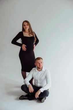 Stüdyoda beyaz bir geçmişi olan mutlu evli bir çift, hamile bir kız ve kocası.