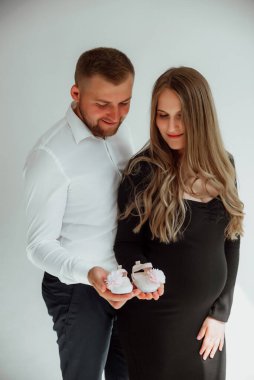 Stüdyoda beyaz bir geçmişi olan mutlu evli bir çift, hamile bir kız ve kocası.