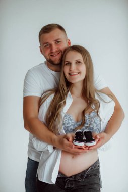 Stüdyoda beyaz bir geçmişi olan mutlu evli bir çift, hamile bir kız ve kocası.