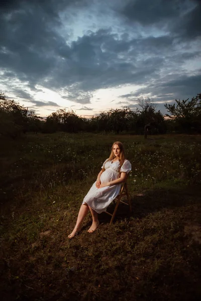 Pregnant Girl White Dress Sits Chair Garden Background Sunset — Stock Photo, Image