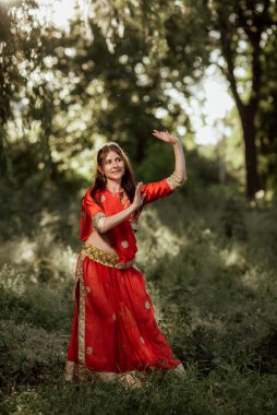 Kız ulusal Hindu kıyafetleri giymiş, kırmızı renkli.