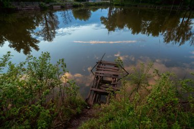 Gün batımında nehir ve ağaçlarla doğal manzara