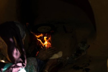 Güneşli bir günde eski köyün mutfağında şapkalar yapan yaşlı bir kadın.