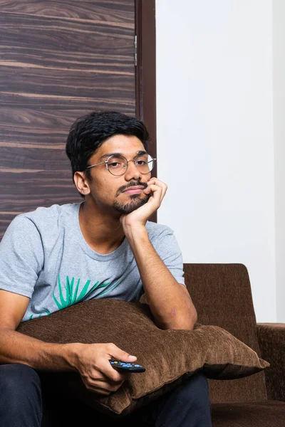 Young Indian Boy Holding Television Remote While Sitting Sofa Looking — Stock Photo, Image