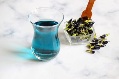 Sağlıklı içecekler, organik mavi kelebek bezelye çiçeği çayı limes ve limon, gri beton arka plan kopya alanı üstten görünüm