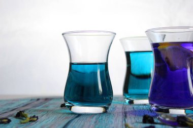 Sağlıklı içecekler, organik mavi kelebek bezelye çiçeği çayı limes ve limon, gri beton arka plan kopya alanı üstten görünüm