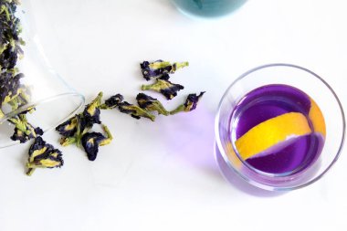 Sağlıklı içecekler, organik mavi kelebek bezelye çiçeği çayı limes ve limon, gri beton arka plan kopya alanı üstten görünüm