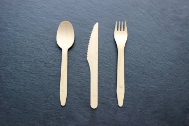 Eko kağıt sofra takımı. Kağıt bardaklar, tabaklar ve arka planda ahşap çatal bıçak takımı. Geri dönüşüm konsepti. Üst görünüm.