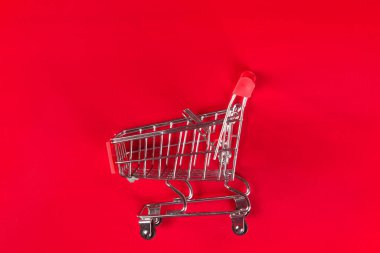 Kırmızı arkaplanda boş kırmızı alışveriş arabası.