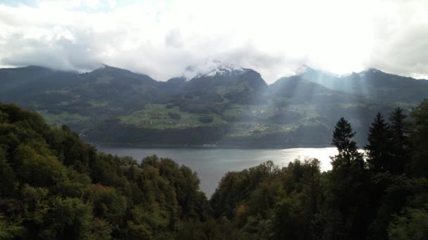 Солнечные лучи пробиваются сквозь облака над озером Уоллен в Швейцарии. — стоковое видео