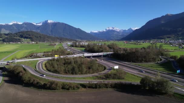 Dron oběžná dráha kolem dálnice obklopen velkými horami ve Švýcarsku — Stock video