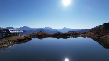 Manzaralı dağ gölü ve İsviçre bayrağı ve gondol istasyonu ile panorama