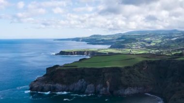 Bulutlar adanın kayalık kayalıklarına gölge düşürüyor. Azores 'deki Sao Miguel.