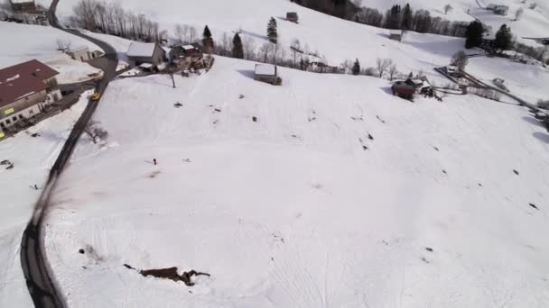 Aerial po sportowcach zimowych zjeżdżających ze stoku do szwajcarskiego ośrodka wypoczynkowego — Wideo stockowe
