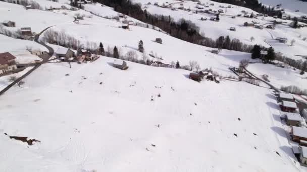 Następujący narciarze po stoku narciarskim w pięknym szwajcarskim ośrodku narciarskim, orbita lotnicza — Wideo stockowe